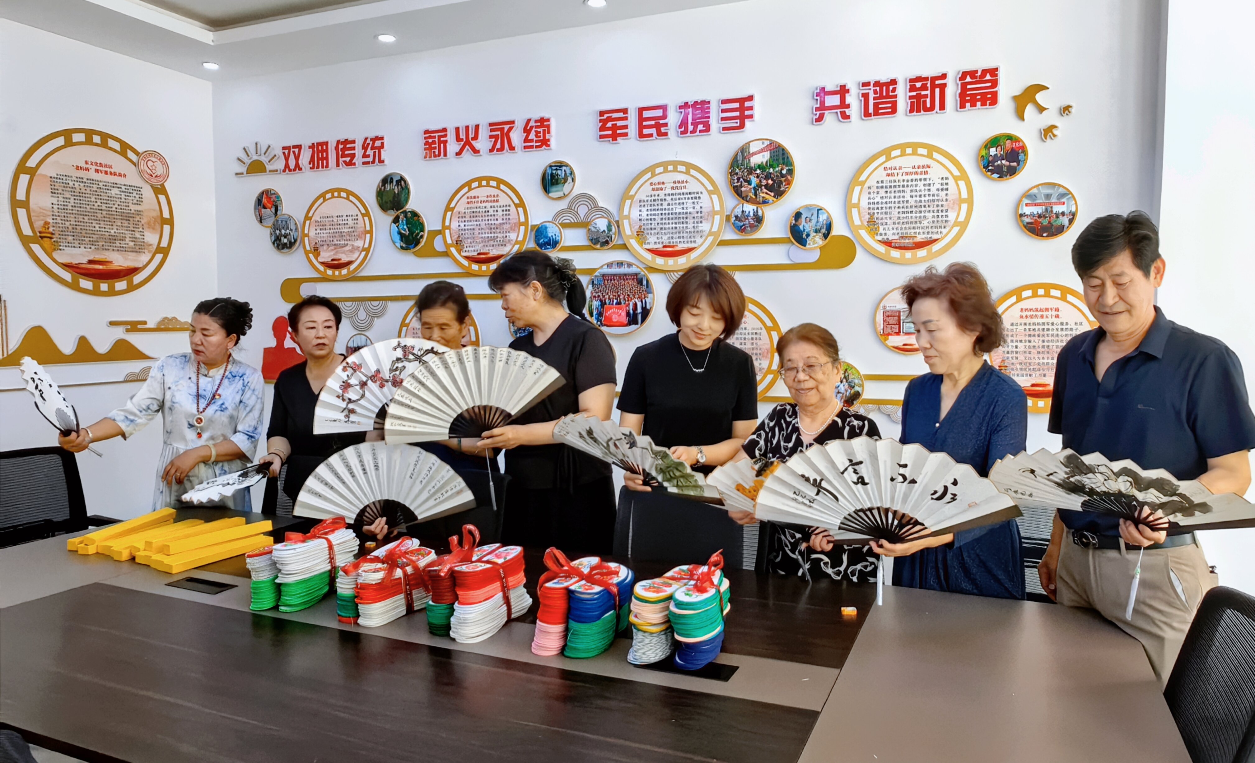 老妈妈拥军服务队成员互相看给兵孩子的扇子（孙艳摄）_proc.jpg